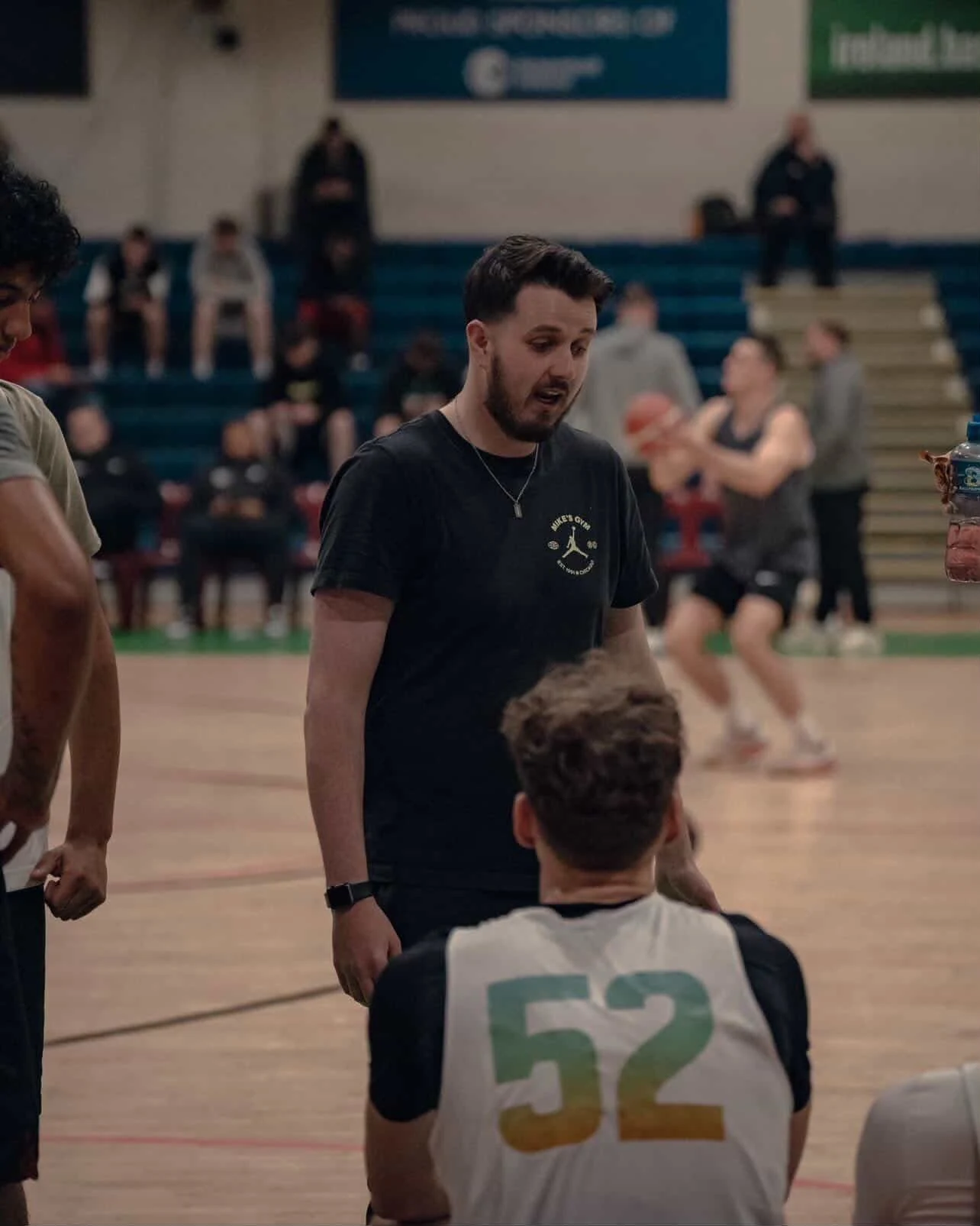 Jack Curran supporting a basketball player during practice